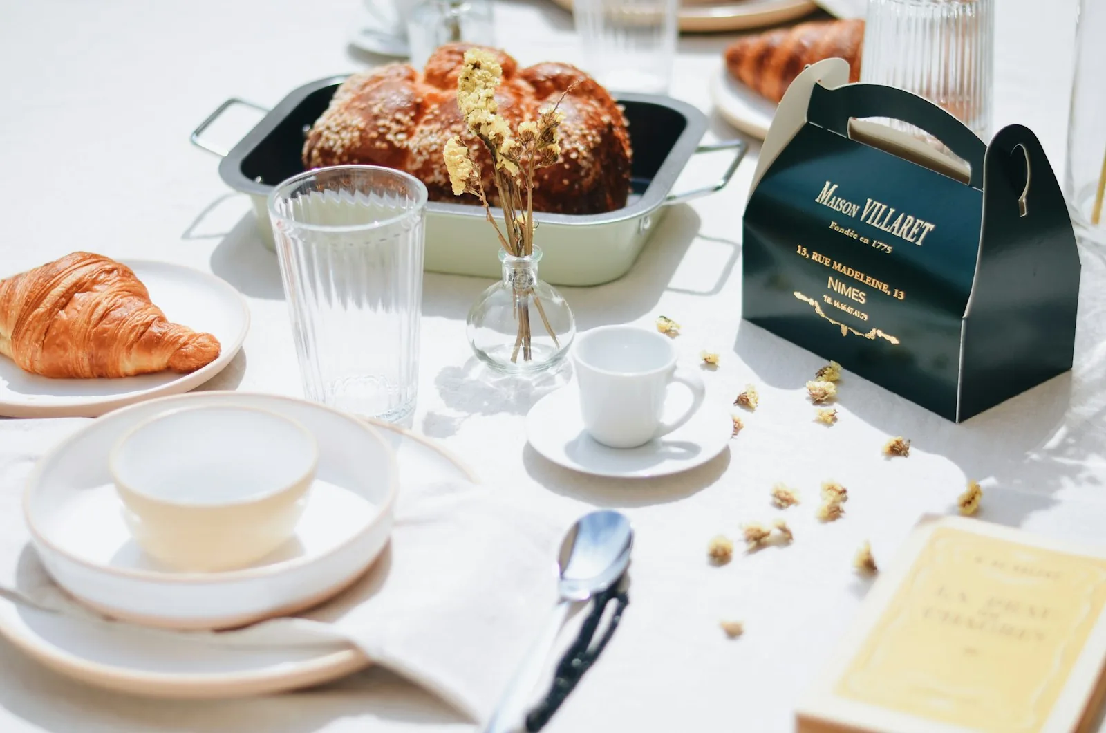 Petit-déjeuner servi sur une table en bois, avec pain et couverts