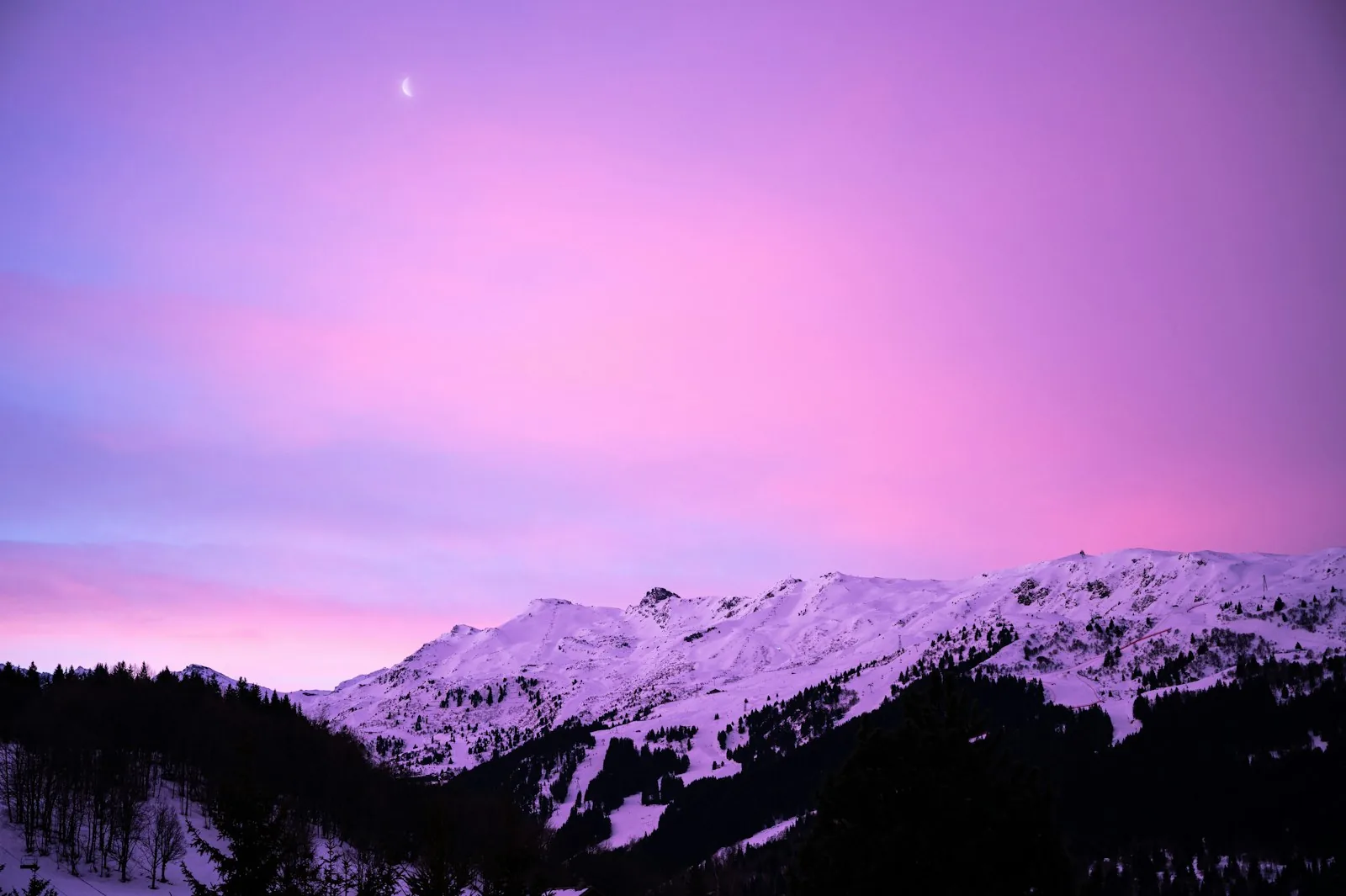 Sommets enneigés de Méribel sous un ciel rose au crépuscule